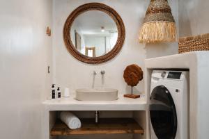 Un baño con lavabo y lavadora. en Chic Elysium - Serenity, en Naxos Chora
