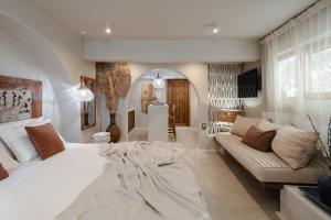 Un dormitorio con una gran cama blanca y un sofá. en Chic Elysium - Serenity, en Naxos Chora