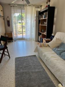 a living room with a couch and a book shelf at Joana's House in La Grande-Motte