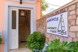 a sign on the side of a house with a welcome sign at Anemos Studios & Apartments in Póros Kefalonias