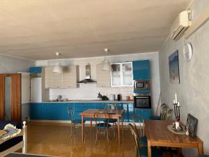 a kitchen with blue cabinets and a table and chairs at La terrazza Iseana in Predore