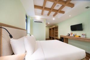 a hotel room with a bed and a television at Nicecy Hotel - Trương Quyền in Ho Chi Minh City