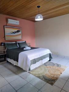 una camera da letto con un letto e una parete rosa di Veraneio Recanto dos Ipês a Pirenópolis