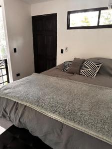 Una cama o camas en una habitación de Nanku - mini hogar cerca de la playa