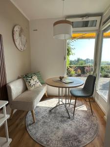a living room with a couch and a table and chairs at Kleine Perle mit Bodenseeblick und Sonnenterrasse in Daisendorf