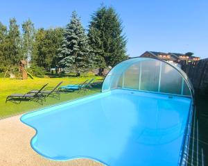 a blue swimming pool with a glass dome on top at Penzion NAROZI Lipno in Černá v Pošumaví