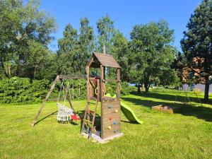 a playground with a slide and a swing at Penzion NAROZI Lipno in Černá v Pošumaví