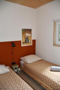 a bedroom with two beds and a window at Black Cabin Veluwe - Wellness in het bos - Airco & Sauna in Putten