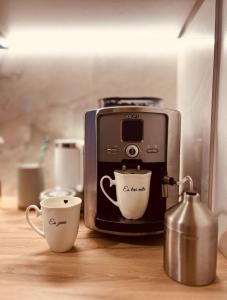 a coffee maker with two cups on a counter at Pineplace residence in Jūrmala +17 photos