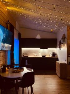 a room with a table and a kitchen with lights at Pineplace residence in Jūrmala