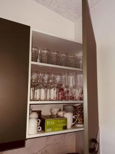 a cupboard filled with lots of glasses and dishes at Pineplace residence in Jūrmala
