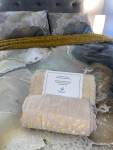 a bed with two pillows and a sign on it at Sunset View Self- Catering Yzerfontein in Yzerfontein