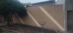 Una pared con una canasta frente a un edificio. en Casa em Presidente Prudente, en Presidente Prudente