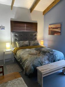 a bedroom with a large bed with a wooden headboard at Sunset View Self- Catering Yzerfontein in Yzerfontein
