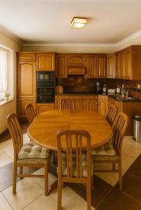 une cuisine avec une table et des chaises en bois dans l'établissement Guesthouse Nestoria Living, à Banja Luka