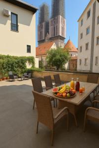 a table with a plate of fruit on it on a patio at HelloZagreb Apartment in Zagreb