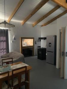 a living room with a table and a refrigerator at Sunset View Self- Catering Yzerfontein in Yzerfontein