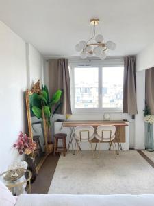 un soggiorno con tavolo, sedie e finestra di Eiffel Tower View - Charming Suite a Parigi Altre 17 foto