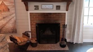 a brick fireplace in a living room with a mantle at Connie's Retreat - 3 Bedrooms, 2 Baths, Sleeps 11 farmhouse in Tellico Plains