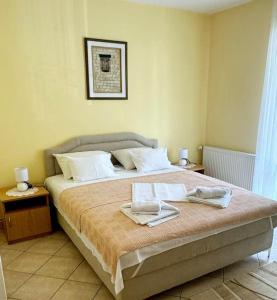 a bedroom with a large bed with two towels on it at Apartments Mitrovići Miločer in Sveti Stefan