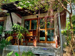 a house with a large window on the side of it at Chook Dee Resort in Baan Tai