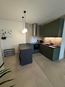 a kitchen with green cabinets and a sink and a table at Appartamenti a Carpi in Carpi +35 photos