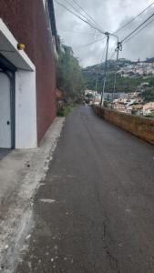 an empty street next to a red brick building at Casa do Mar in Funchal +2 photos