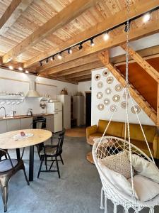 a room with a table and chairs and a kitchen at Szumidomki strefa z jacuzzi sauna widok na potok las in Zawoja