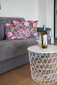 a bottle of wine on a table next to a couch at Olive Scent in Gouves +34 photos