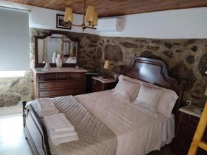 a bedroom with a bed and a vanity and a mirror at Belo Encanto do Paiva in Castelo de Paiva
