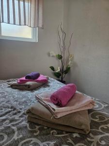 zwei Kissen und Handtücher liegen auf einem Bett in der Unterkunft MM apartman in Mladenovac