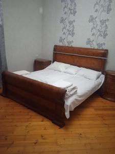 a bed with a wooden headboard in a bedroom at Sweet dreams in Baku