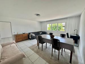 a living room with a table and a couch at Moderne 65m2 Wohnung mit Garten am Waldrand nähe Basel in Rodersdorf