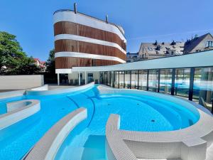 a large swimming pool in front of a building at Baltic Waves Resort & SPA Międzyzdroje 3 in Międzyzdroje