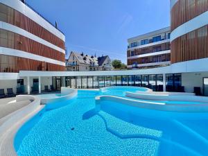 an image of a swimming pool in a building at Baltic Waves Resort & SPA Międzyzdroje 3 in Międzyzdroje