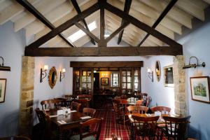 a dining room with wooden tables and chairs at The Windmill Inn in Collingham