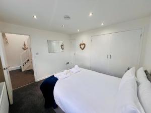 Un dormitorio con una gran cama blanca con toallas. en The Barbican Penthouse, en Plymouth