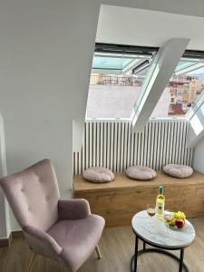 a living room with a chair and a table at A top-floor modern apartment Located 100 meters from the beach in Fuengirola