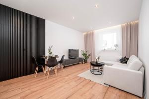 a living room with a white couch and a table at BYTOM One 24H Strefa Komfortu in Bytom