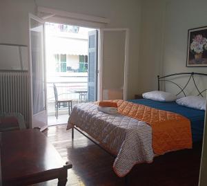 a bedroom with a bed and a balcony with a table at Comfort bed in a room 5' from metro in Athens