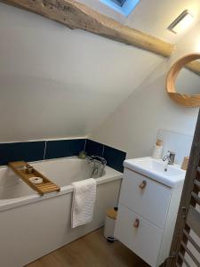 a bathroom with a bath tub and a sink at Le nid de Bertille in Le Vaudreuil