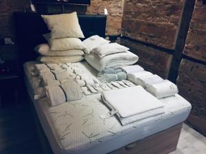 ein Bett mit weißen Decken und Kissen darauf in der Unterkunft El antiguo taller de Guantes in Madrid