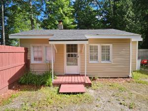 a small house with a red fence in front of it at The Honey Bear Cabins in Lincoln Junction