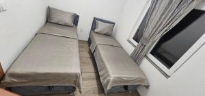 two beds in a small room with a window at Green Oasis Apartments in Sarajevo +40 photos