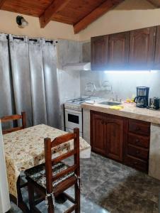 a kitchen with a table and a sink and a stove at Belgrano in San Fernando del Valle de Catamarca