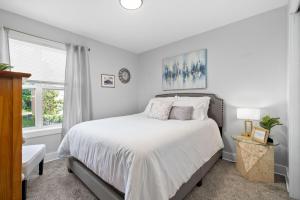 Un dormitorio blanco con una cama y una ventana. en The Lofts of Downtown - 540 N 2nd St - Unit 202 - Charming 2-Bedroom in the Heart of Clarksville TN, en Clarksville