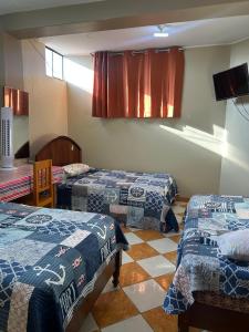 a hotel room with three beds and a tv at Mulato & Chaparri in Chongoyape +11 photos