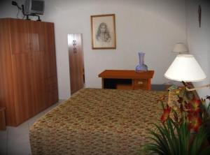 a bedroom with a bed and a lamp and a table at Hotel Ristorante La Bettola in Sasso Marconi