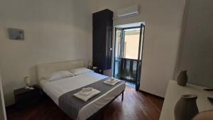 a bedroom with a bed with two towels on it at La Città Vecchia house Salerno centro in Salerno