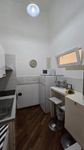 a small white kitchen with a sink and a counter at La Città Vecchia house Salerno centro in Salerno